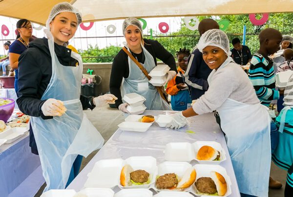 People volunteering at a food bank by packaging up burgers.