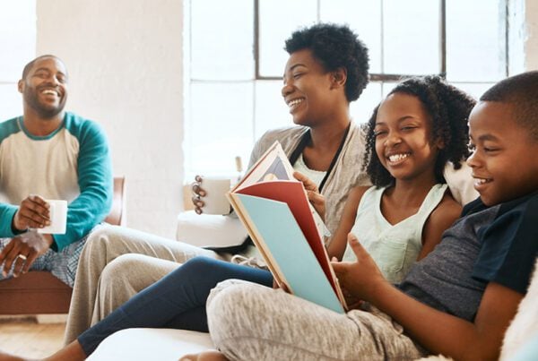 Family reading and laughing together on in their living room.